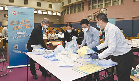 二零二二年三月三十日，勞工及福利局同事於觀塘振華道體育館的「防疫服務包」包裝中心參與包裝工作。