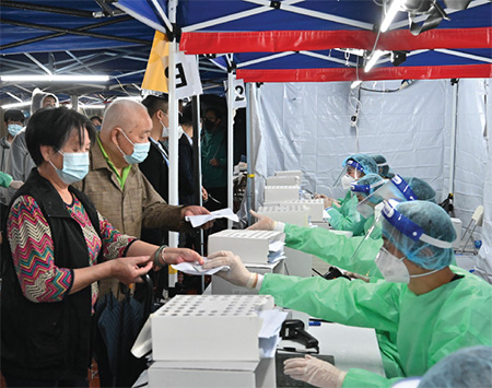 Staff members of LWB conducted "RTD" operation in the specified "restricted area" in Kwai Tung House, Tung Tau (II) Estate, Wong Tai Sin on 23 and 24 March 2022, going to the frontline to fight the epidemic. They prepared anti-epidemic supplies, including RAT kits, for residents subject to compulsory testing under heavy rain.
