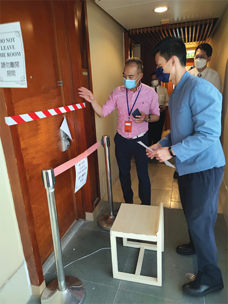 Staff of the dedicated compliance team of the Designated Quarantine Hotel (DQH) Scheme Office under the then FHB conducted various drills with staff of the hotels which were new to the scheme to help them familiar with the procedures for handling various situations. Photo shows the staff of the dedicated compliance team and hotel staff carrying out a drill for handling confirmed cases.