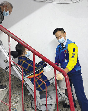 取得樓梯機操作資格的義工隊隊員陳偉亮先生為唐樓居民提供樓梯機服務。