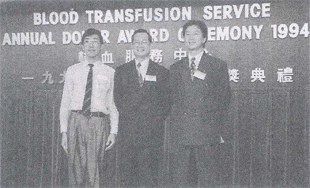 关先生(左)于一九九四年在红十字会周年捐血颁奖典礼上获颁捐血第七十五次的纪念章。