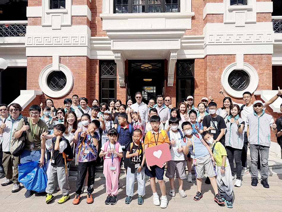 Group photo of the volunteer team and children at the Parade Ground of Tai Kwun.